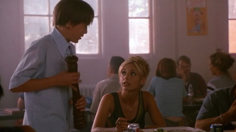 Sarah Michelle Gellar's unnamed character sitting at a cafeteria table in "She's All That"