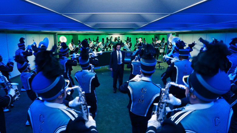 Mark S and Helly R are surrounded by a marching band performing choreography and merriment in Severance