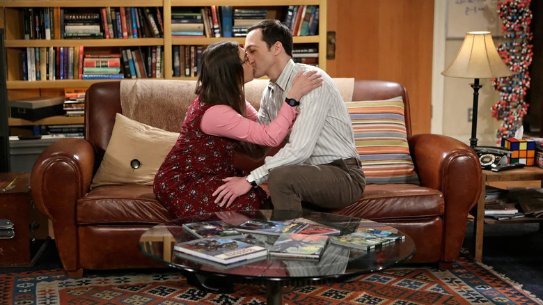 Amy and Sheldon kissing on the couch in The Big Bang Theory