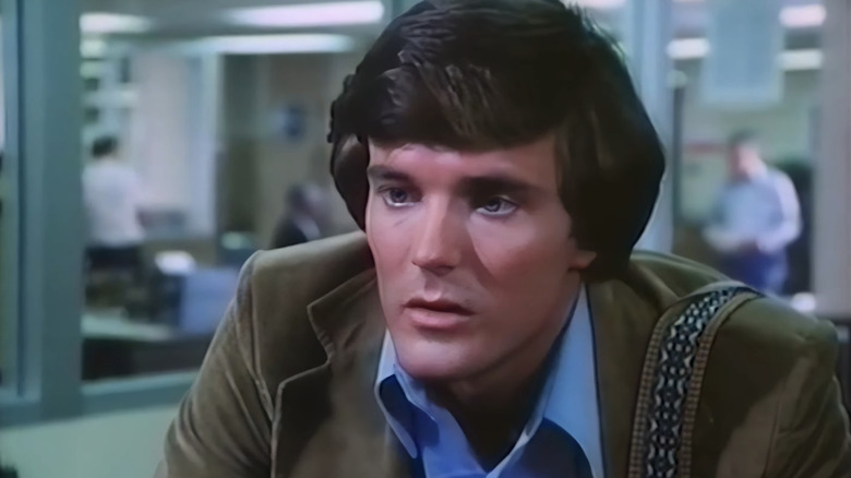 Nicholas Hammond sebagai Peter Parker terlihat dari dekat duduk di ruang redaksi di The Amazing Spider-Man