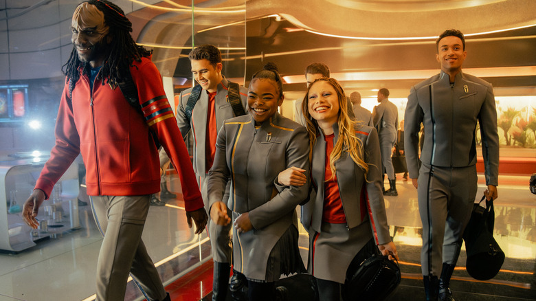 Karim Diané as Jay-Den, George Hawkins as Darem, Kerrice Brooks as SAM, Bella Shepard as Genesis, and Sandro Rosta as Caleb walking down a hallway in uniform in Star Trek: Starfleet Academy