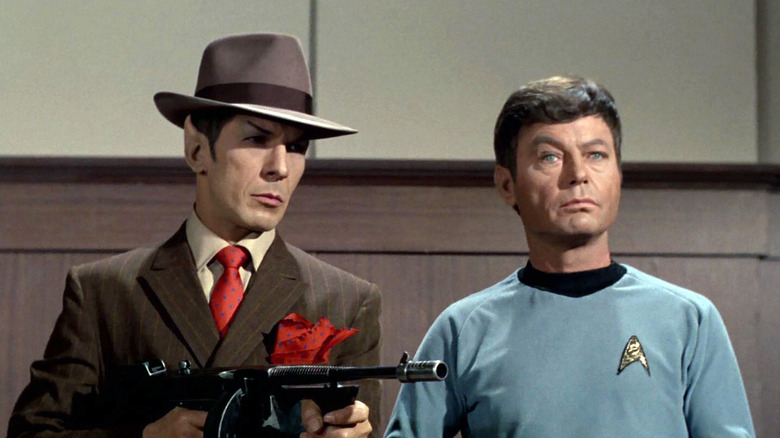 Spock holding a Tommy gun in a gangster suit and Dr. McCoy in Star Trek: The Original Series