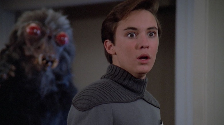 Wesley Crusher, scared, with a monster behind him on Star Trek: The Next Generation