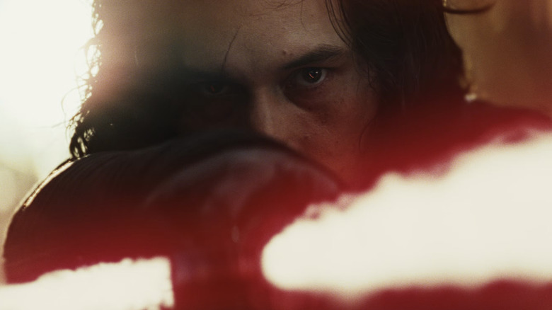 Star Wars: The Last Jedi - Kylo Ren staring with hatred and pointing his red lightsaber at Luke Skywalker (offscreen)