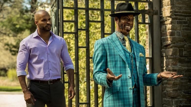 Shadow and Mr. Nancy standing next to a gated entrance in American Gods