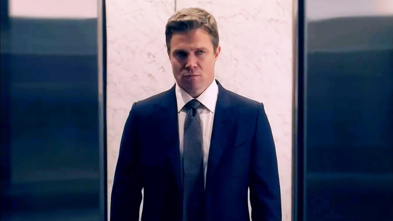 Stephen Amell as Ted Black standing in an elevator on Suits LA