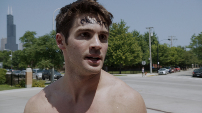 Steven R. McQueen as Jimmy Borrelli stands in the street with the word candidate on his forehead in Chicago Fire