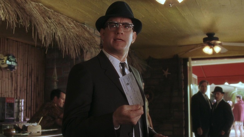 Tom Hanks as Carl Hanratty holds a counterfeit check in 