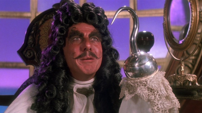 Dustin Hoffman as Captain James Hook smiles as he holds up his hook in Hook