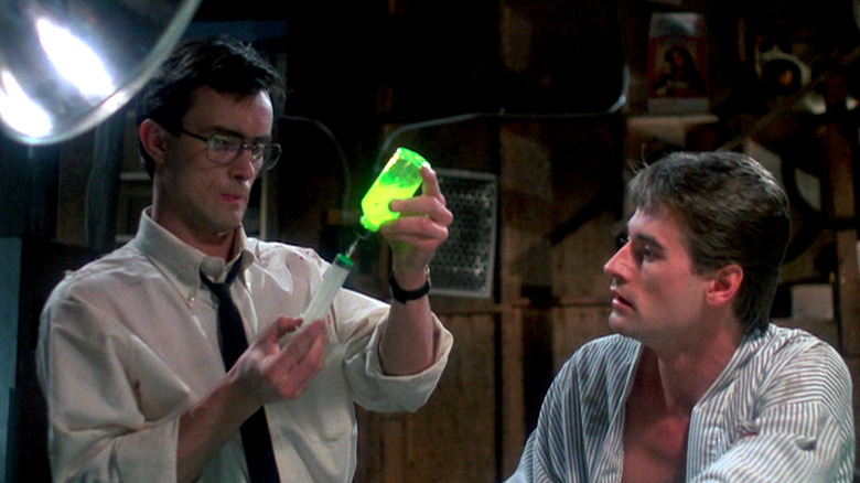 Herbert West fills a syringe with serum as Dan watches