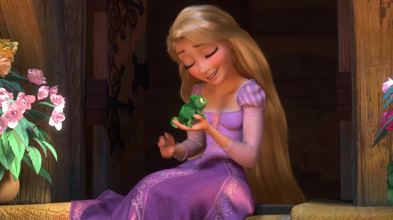 Rapunzel (Mandy Moore) holding her chameleon companion Pascal in Tangled