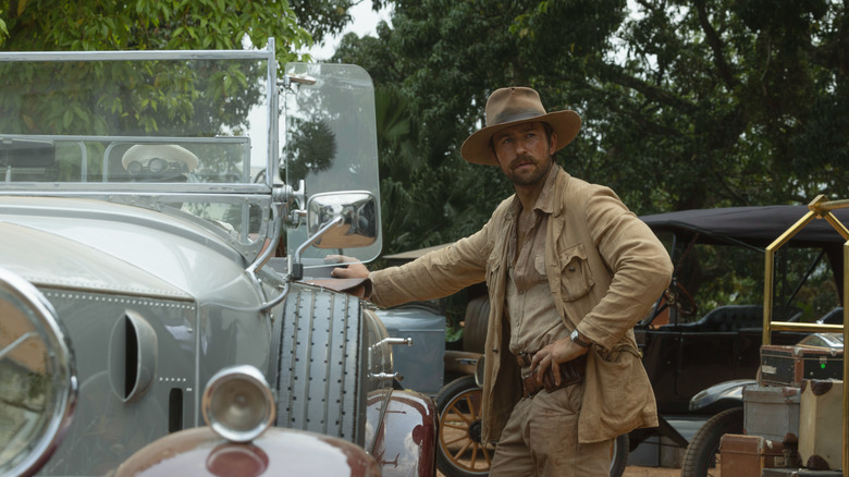 Spencer Dutton by Brandon Sklenar relying against a car in 1923