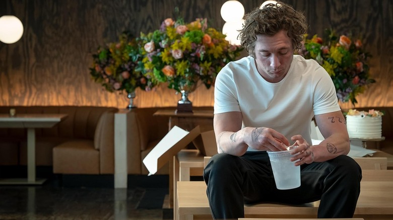 Jeremy Allen White as Carmy holding a cup in The Bear