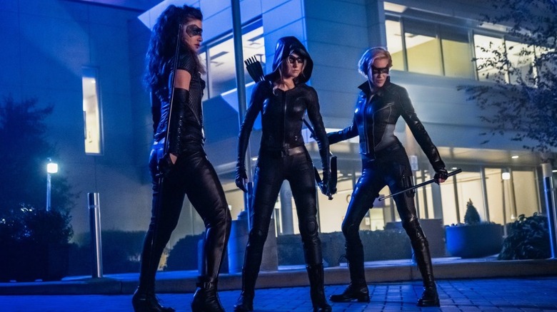Katie Cassidy, Katherine McNamara, and Juliana Harkavy posing together as Black Siren, Green Arrow, and Black Canary in the Arrow episode Green Arrow & the Canaries