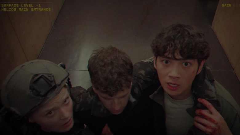 Sean Kaufman as Alex Poletov and Ines Asserson as A.J. Jarrett carrying a wounded Barrett Carnahan as Marcus Haskell in between them in For All Mankind
