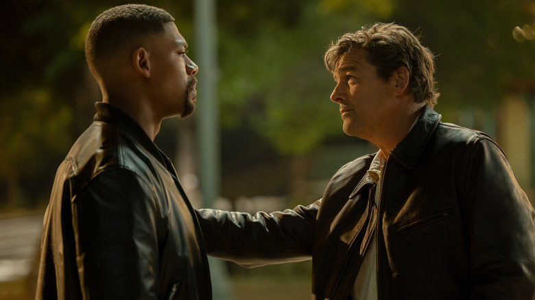 Kyle Chandler's Hal Jordan puts his hand on the arm of Aaron Pierre's John Stewart as they stand face to face in Lanterns