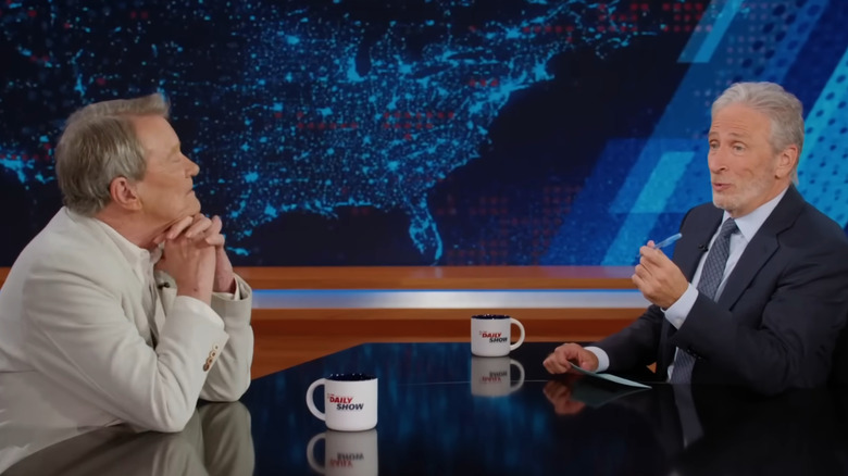 Steve Kroft e Jon Stewart conversando sobre o assentamento da Paramount no Daily Show
