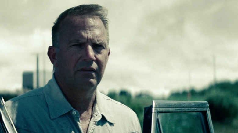 Kevin Costner's Jonathan Kent stands against a grey sky in Man of Steel