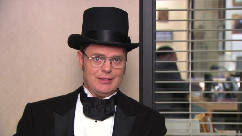 Rainn Wilson as Dwight Schrute in his top hat and suit in the conference room in the Office episode The Farm