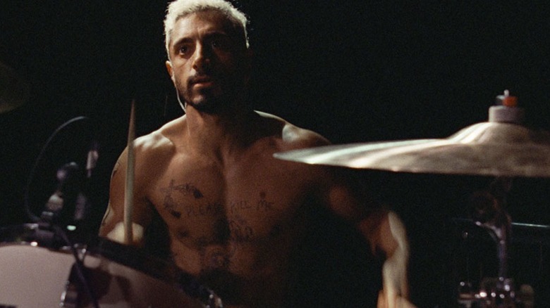 Shirtless drummer with earbud