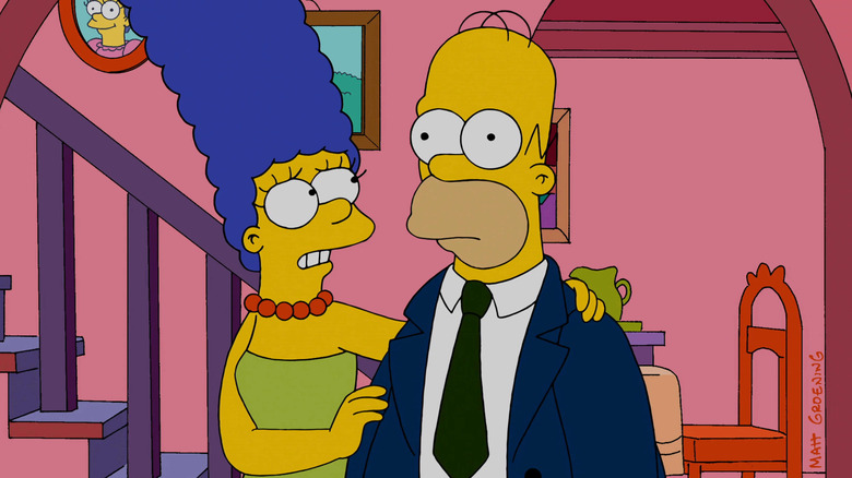 Os Simpsons Marge coloca a mão no ombro de Homer enquanto ele olha sem