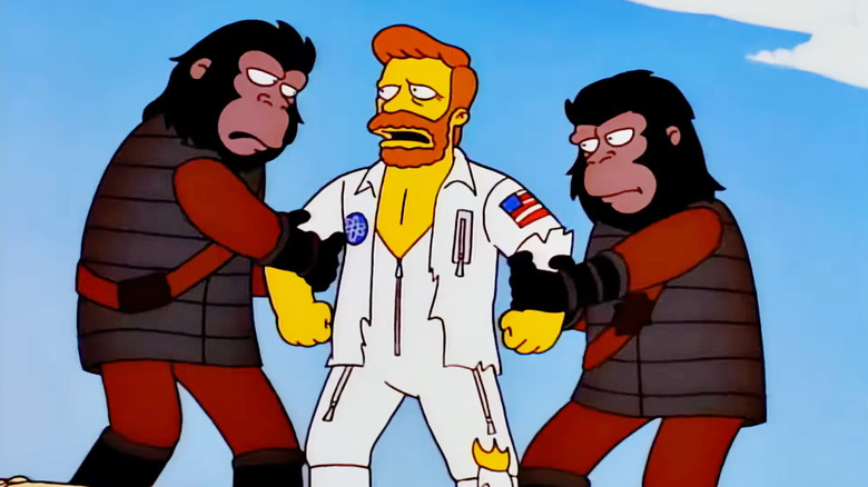 Troy McClure as Taylor being held still by a pair of Apes in The Simsons