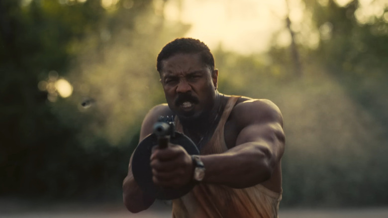 Michael B. Jordan as Smoke shooting his tommy gun in Sinners