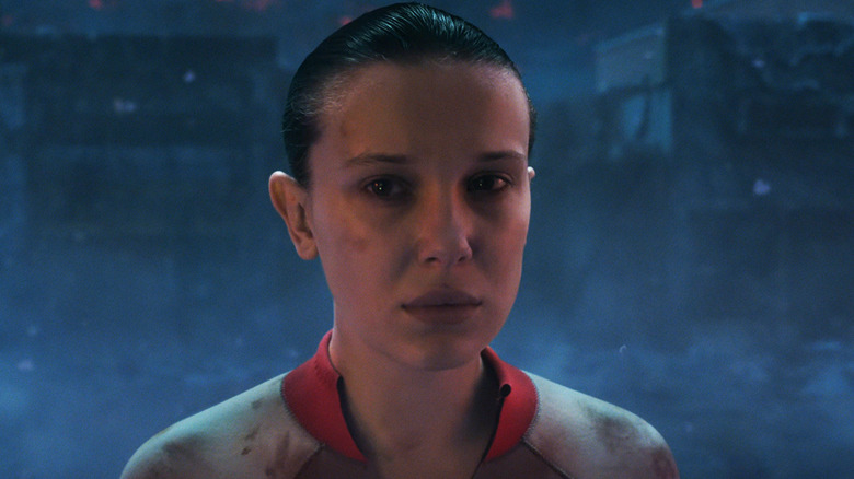 Millie Bobby Brown's Eleven looks sad as she stands in the Upside Down in Stranger Things