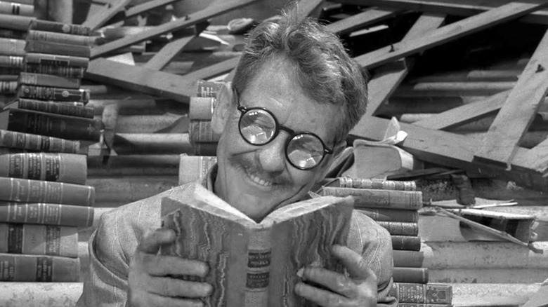 Henry (Burgess Meredith) reading a book on 