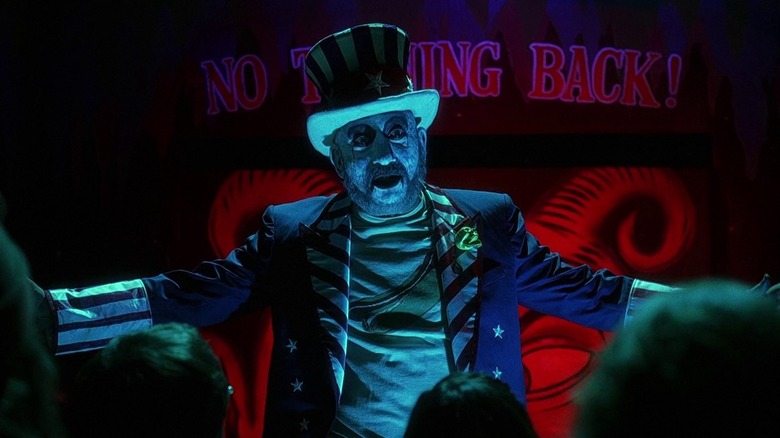 Captain Spaulding (Sid Haig) towers over a crowd in front of his museum in House of 1000 Corpses (2003)
