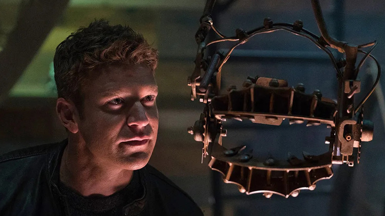 Logan (Matt Passmore) looking at a torture device in Jigsaw (2017)