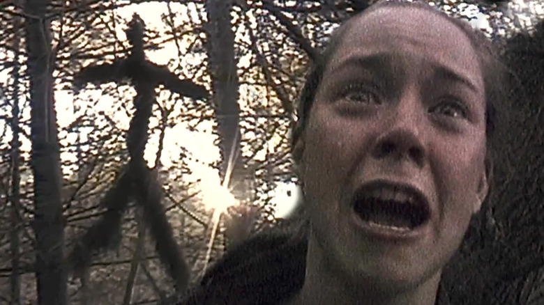 Heather Donahue (Heather Donahue), scared, is stalked by a mysterious shadow in the middle of the forest in The Blair Witch Project (1999)