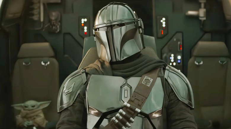 Din Djarin riding with Grogu in their spaceship in The Mandalorian and Grogu