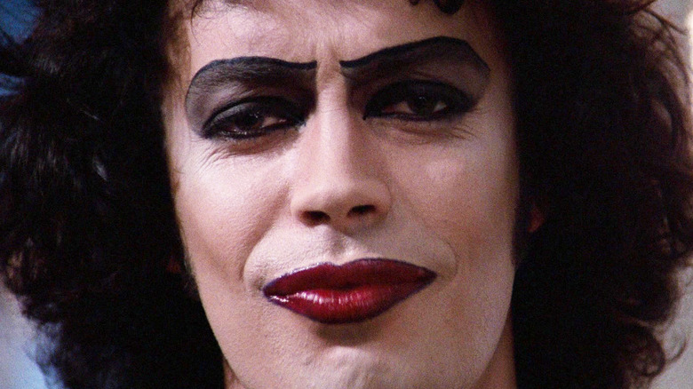 Tim Curry as Dr. Frank-N-Furter smiling in The Rocky Horror Picture Show