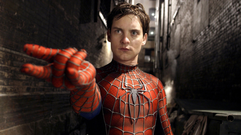 Tobey Maguire as Spider-Man trying to shoot his webs in an alley in Spider-Man 2
