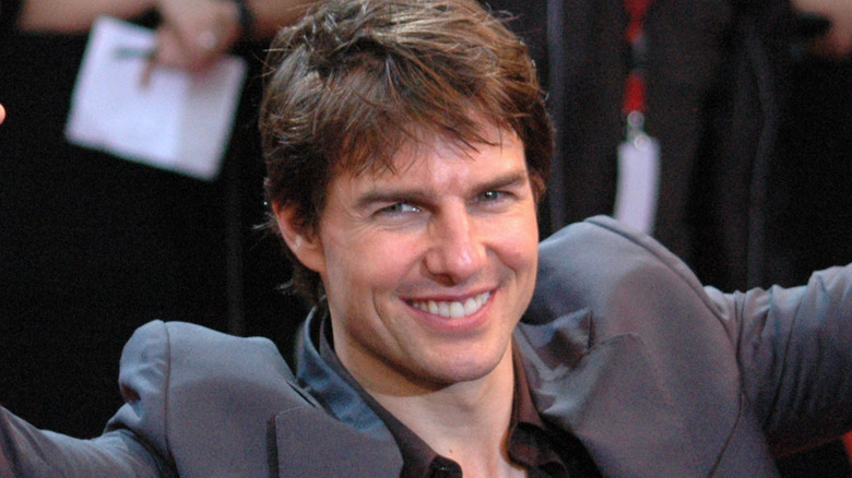 Tom Cruise with arms up on red carpet