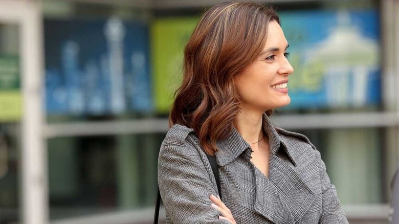 Torrey DeVitto's Dr. Natalie Manning stands outside smiling in Chicago Med