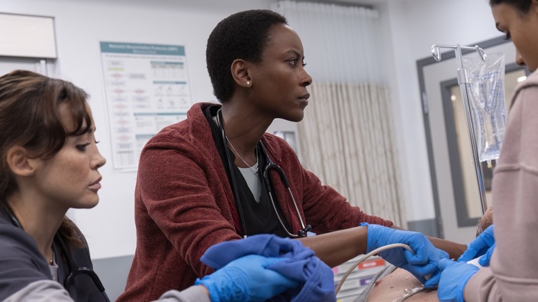 Dr. Collins looks concerned as she operates on a patient in season 1 of The Pitt