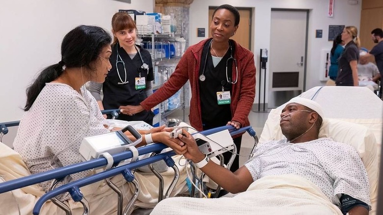 Dr. Collins smiles as two patients share a nice moment in The Pitt season 1