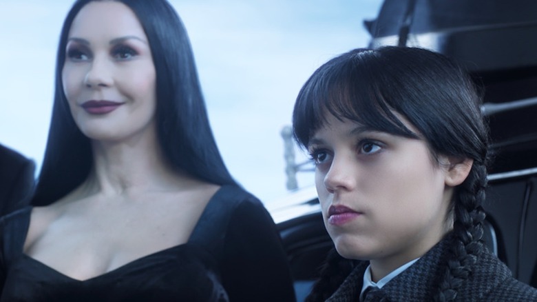 Morticia smiles while Wednesday sulks in Wednesday Season 1