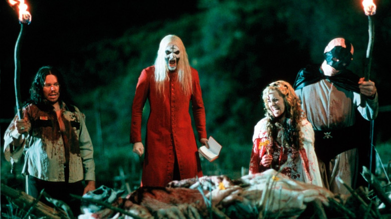 Rufus (Robert Allen Mukes), Otis (Bill Moseley), Baby (Sheri Moon Zombie ), and Tiny (Matthew McGrory) burn tourists on a pyre in House of 1000 Corpses (2003)