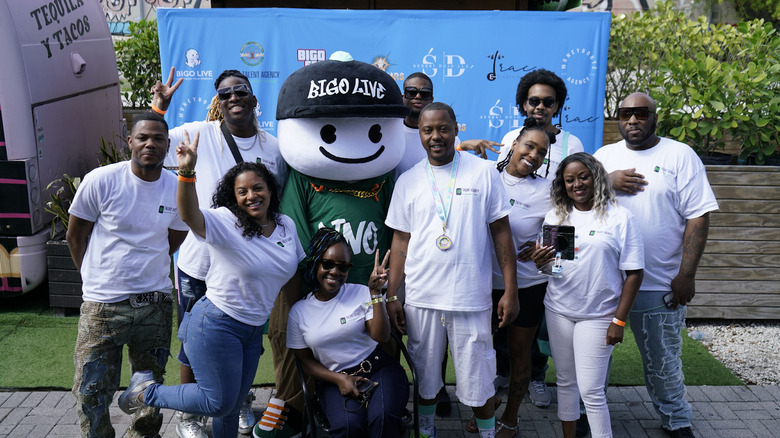 People wearing matching t-shirts standing around a mascot