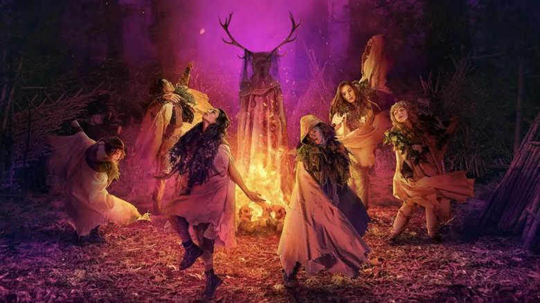 Yellowjackets season 3 poster: Natalie, Tai, Lottie, Van, Misty, and Shauna dancing around the Antler Queen in fire