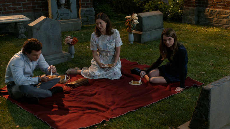 Montana Jordan as Georgie Cooper, Zoe Perry as Mary Cooper, and Raegan Revord as Missy Cooper sitting in a graveyard on Georgie & Mandy's First Marriage