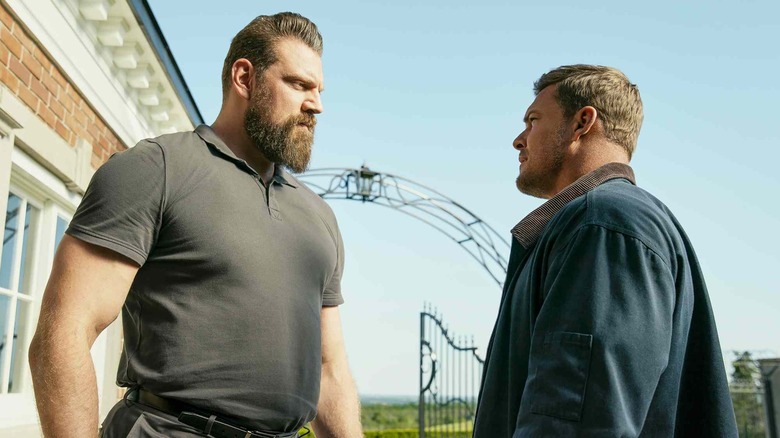 Paulie towering over Jack Reacher in Reacher