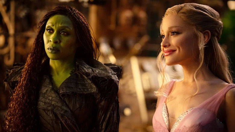 Elphaba looking confused and Glinda smiling at the Wizard in Wicked: For Good