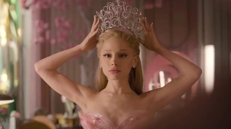 Glinda placing her crown on her head in a mirror in Wicked: For Good