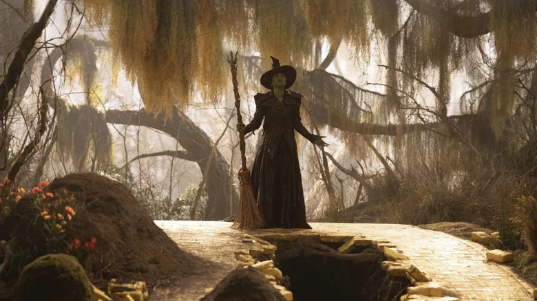 Elphaba standing with her broom near the hole in the Yellow Brick Road in Wicked: For Good
