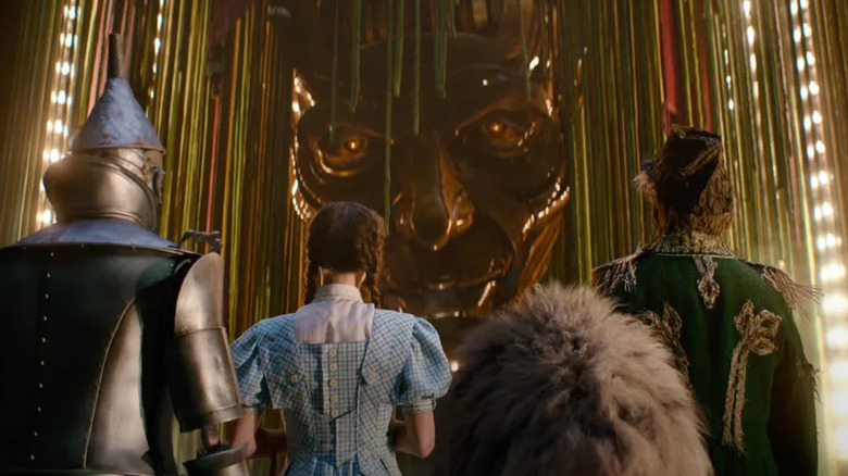 The Tin Man Dorothy Cowardly Lion and Scarecrow looking up at the Wizard of Oz in Wicked: For Good