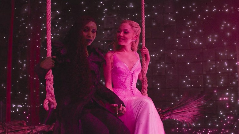 Elphaba and Glinda sitting on brooms